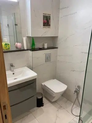 a white bathroom with a toilet and a sink at Bright & cozy studio in Oasis, close to train station in Casablanca
