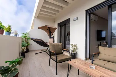 a patio with a hammock and a chair on a balcony at New 8th floor Terrace 5 min from train stations in Casablanca