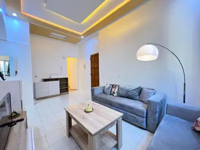 a living room with a couch and a table at Cosy apartment steps from shore & public transport in Rabat