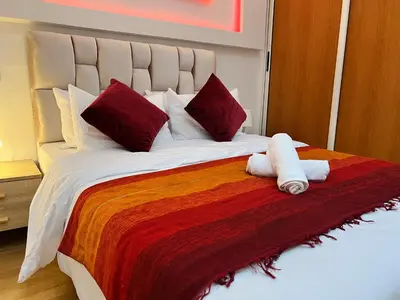 a large bed with two stuffed animals on it at Cosy apartment steps from shore & public transport in Rabat