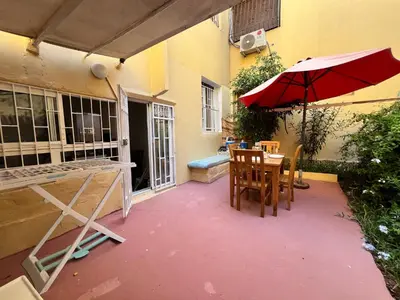 a patio with a table and an umbrella at Cosy apartment steps from shore & public transport in Rabat