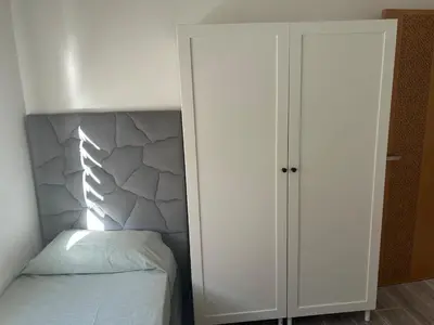 a bedroom with a bed and a white cabinet at Apartamento Temara Morroco in Temara