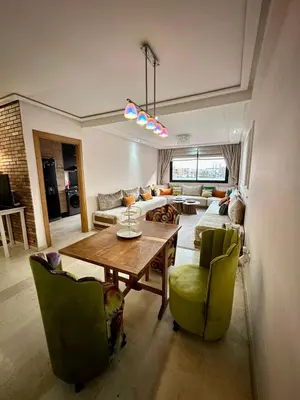 a living room with a wooden table and green chairs at Twin Center View Apt in Maarif in Maarif