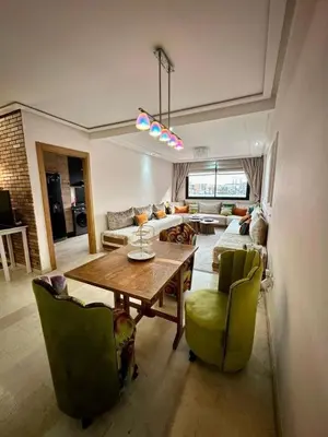 a living room with a wooden table and green chairs at Twin Center View Apt in Maarif in Maarif