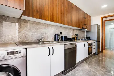 a kitchen with white cabinets and a dishwasher at Prestigieux appartement 3 chambre plein cœur CFC in Casablanca