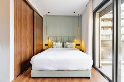 a bedroom with a large white bed and a window at Prestigieux appartement 3 chambre plein cœur CFC in Casablanca