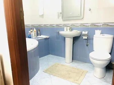 a blue bathroom with a toilet and a sink at Modern Central Apartment in Casablanca in Casablanca