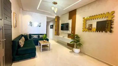a living room with a green couch and a table at Appartement chic Dahomey plage - Rabat & Bouznika, mer et culture in Bouznika