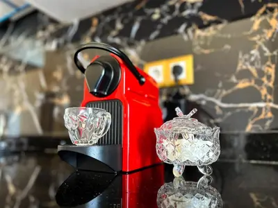 a red toaster sitting on a table with two glasses at Appartement chic Dahomey plage - Rabat & Bouznika, mer et culture in Bouznika