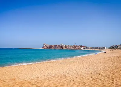 a view of a beach with buildings in the background at Appartement chic Dahomey plage - Rabat & Bouznika, mer et culture in Bouznika