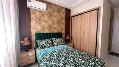 a bedroom with a bed with a green headboard at Appartement chic Dahomey plage - Rabat & Bouznika, mer et culture in Bouznika