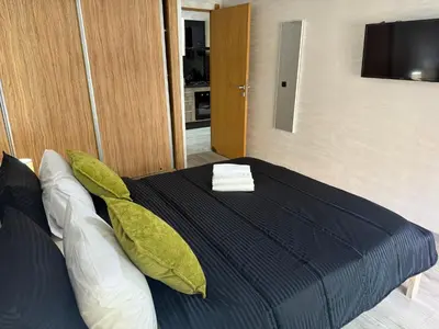 a bedroom with a bed with pillows and a television at Studio Stadium morocco for family in Mohammedia