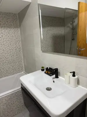 a bathroom with a sink and a mirror and a tub at Studio Stadium morocco for family in Mohammedia