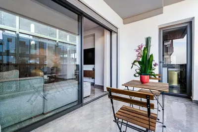 a balcony with a wooden bench and a table with a potted plant at Luxueux appartement 3 chambre en plein cœur CFC NEXT HOUSE 3 in Casablanca