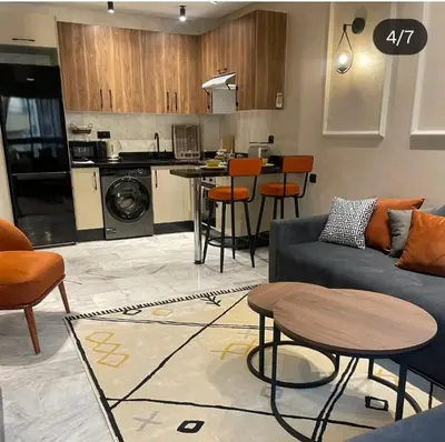 a living room with a couch and a kitchen at Studio Maarif 5 minutes from Mohamed V studium in Casablanca