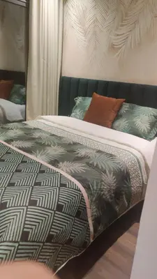 a bed with a black and white comforter and pillows at Studio Maarif 5 minutes from Mohamed V studium in Casablanca