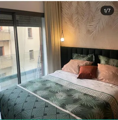 a bed in a bedroom with a large window at Studio Maarif 5 minutes from Mohamed V studium in Casablanca