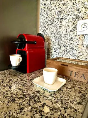 a red coffee maker and two cups on a counter at Pause cosy moderne in Casablanca