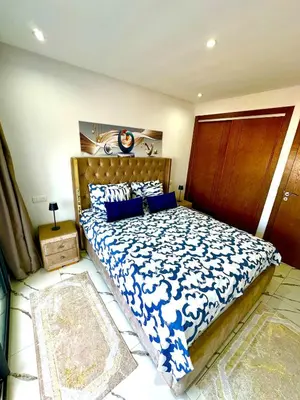a bedroom with a large bed with blue and white sheets at Pause cosy moderne in Casablanca