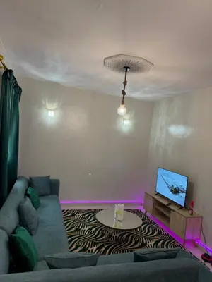 a living room with a couch and a tv at Résidence Haja in Casablanca