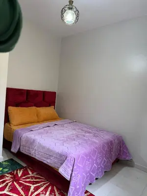 a bed in a bedroom with a purple comforter at Résidence Haja in Casablanca