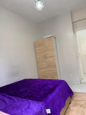 a bedroom with a purple bed and a dresser at Résidence Haja in Casablanca