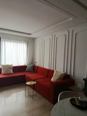 a living room with a red couch and a table at Studio Casablanca Les Princesses amirat in Maarif