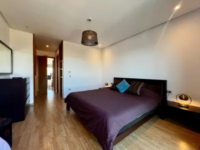 a bedroom with a bed with a purple comforter at Luxurious 1BR Orangeraie - Terrace & Pool in Oulad Akkou