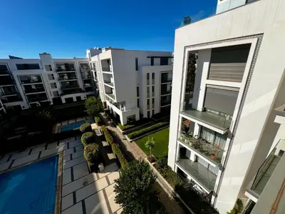 an aerial view of an apartment building with a swimming pool at Luxurious 1BR Orangeraie - Terrace & Pool in Oulad Akkou