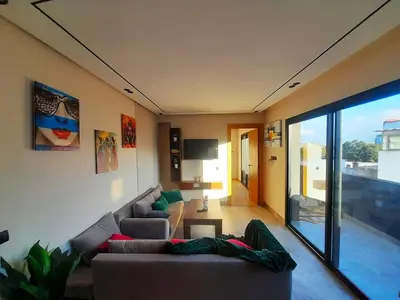 a living room with a couch and a tv at Séjour élégant avec terrasse et vue sur la ville in Casablanca