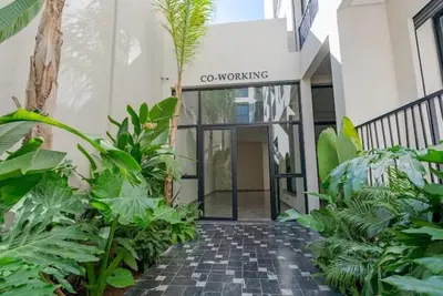 a walkway leading to the entrance to a building with plants at Séjour élégant avec terrasse et vue sur la ville in Casablanca