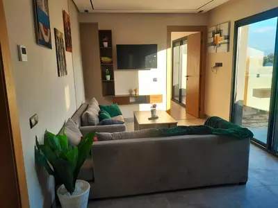 a living room with two couches and a television at Séjour élégant avec terrasse et vue sur la ville in Casablanca