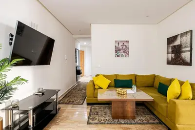 a living room with a yellow couch and a table at Appartement spacieux Océan Rabat in Rabat