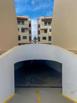 a white archway in front of a building at Appartement bord de mer avec piscine à Bouznika in Bouznika