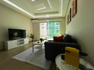 a living room with a couch and a tv at Cozy & Stylish 2BR - Near Arribat Center Mall in Rabat