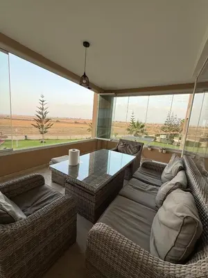 a living room with two couches and a glass table at Evasion apartment with beach and pool views in Bouznika