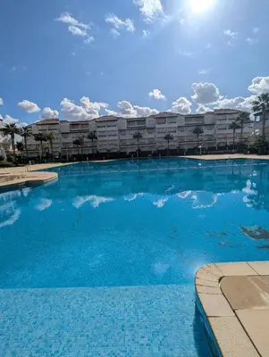 a large blue swimming pool in front of a building at Maison Lalla najat in Sidi Rahal