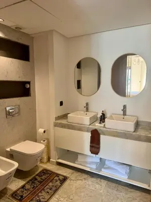 a bathroom with two sinks and a toilet and mirrors at Anfa Ivory Hassan II in Casablanca