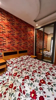 a bedroom with a bed with a floral comforter at Beautiful appartement with pool view in Mohammedia