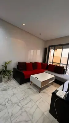 a living room with a red couch and a coffee table at Beautiful appartement with pool view in Mohammedia
