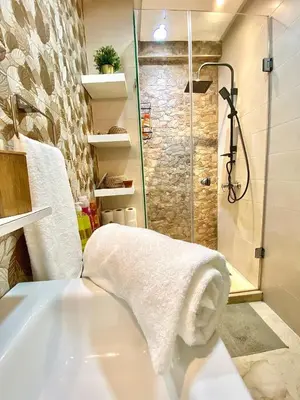 a bathroom with a shower and a tub with a towel at Modern Studio Centre Casa belvédère Tramway & Train Station in Casablanca