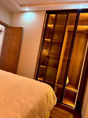 a bedroom with a large wooden cabinet next to a bed at Modern Studio Centre Casa belvédère Tramway & Train Station in Casablanca