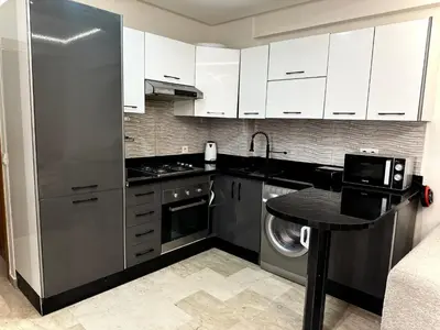 a kitchen with a stainless steel refrigerator and a table at Modern Studio Centre Casa belvédère Tramway & Train Station in Casablanca