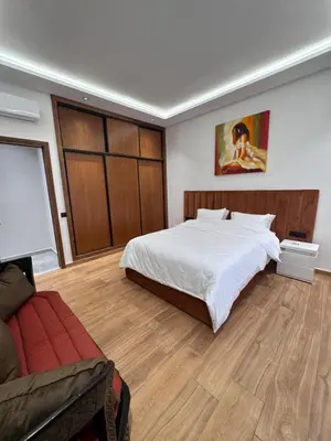 a bedroom with a large bed and a couch at Luxury apartment in Rabat