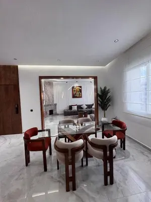 a living room with a table and chairs and a couch at Luxury apartment in Rabat