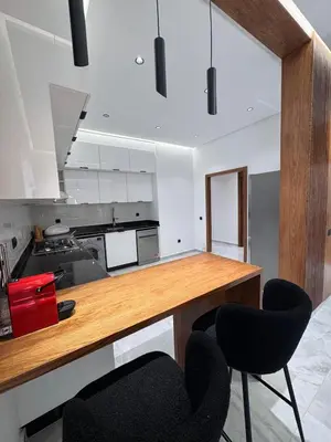 a kitchen with two black chairs and a counter at Luxury apartment in Rabat