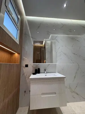a white bathroom with a sink and a mirror at Luxury apartment in Rabat