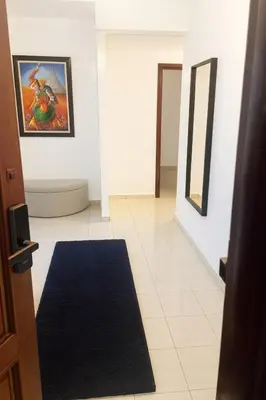 a hallway with a blue rug and paintings on the wall at Casa Bourgogne 2-Bedroom apart, Guarded community in Casablanca