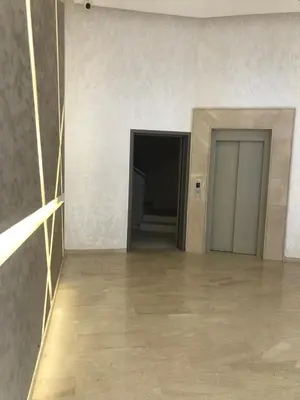 an empty room with two doors and a tile floor at AFCON near rabat complex de football in Bouznika