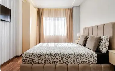 a bedroom with a bed and a large window at Studio charment près de la mosqué Hassan II in Casablanca